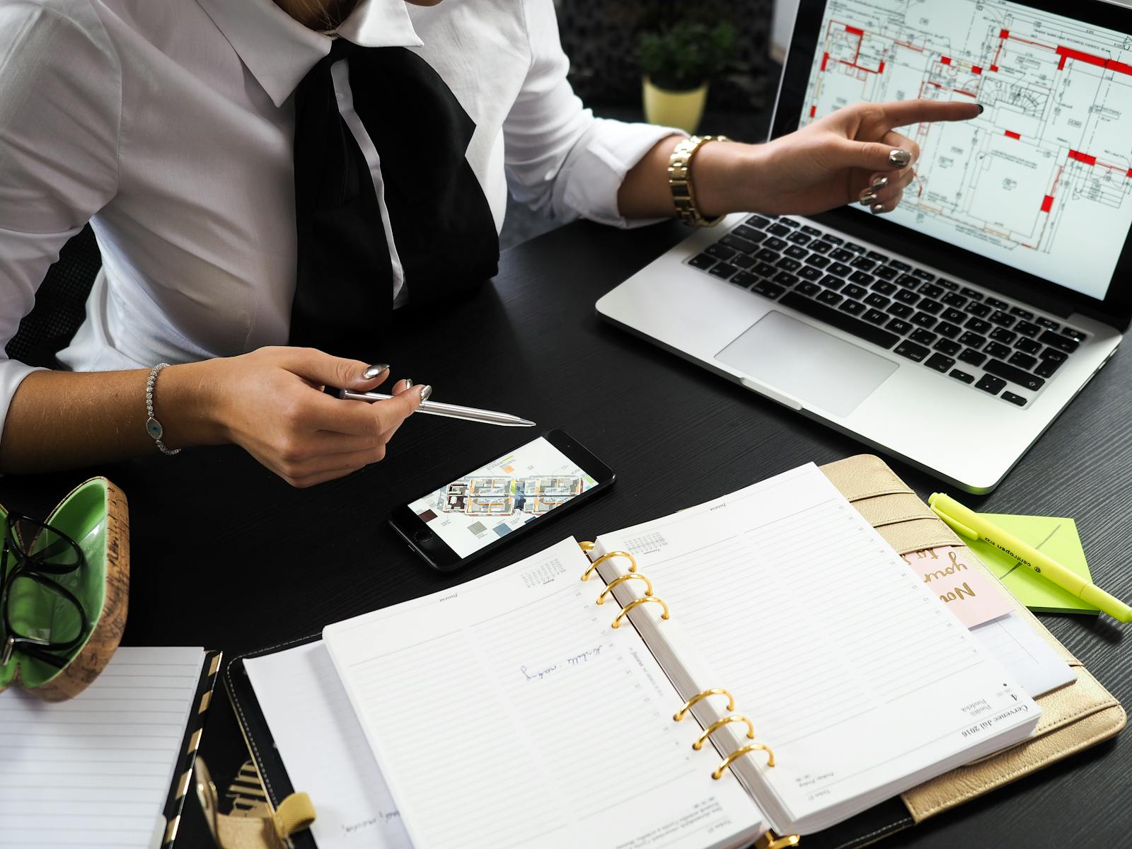 "Sąsiad sprzedał za X, więc moje jest warte tyle samo" – najczęstsze błędy przy samodzielnej ocenie wartości nieruchomości. A business professional working on real estate project plans using multiple devices in an office setting.